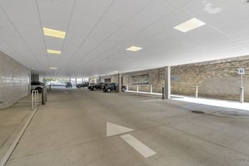 A parking garage with cars and a brick wall